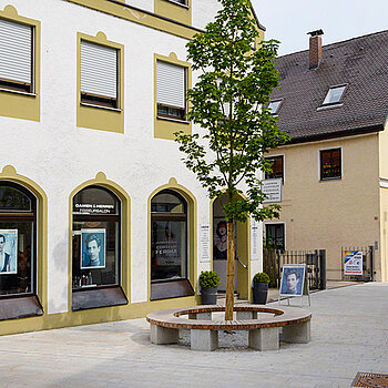 Vor dem Friseurladen in der Weizengasse weitet sich der Straßenraum auf und bietet Platz, auf der Rundbank zu pausieren. (Foto: Stadt Freising)