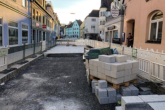 Obere Hauptstraße, Abschnitt Karlwirt-Kreuzung bis Sackgasse: In der Straßenmitte werden die kleinen Natursteine verlegt. Entlang der Fassaden ist das Pflastern mit großen Steinen bereits abgeschlossen. (Foto: Stadt Freising)