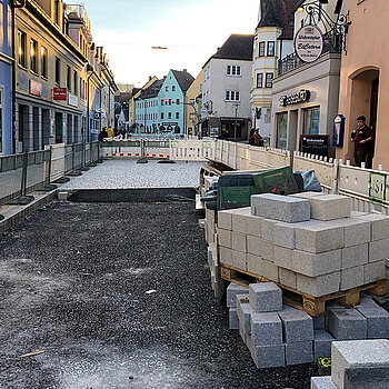 Obere Hauptstraße, Abschnitt Karlwirt-Kreuzung bis Sackgasse: In der Straßenmitte werden die kleinen Natursteine verlegt. Entlang der Fassaden ist das Pflastern mit großen Steinen bereits abgeschlossen. (Foto: Stadt Freising)