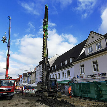 Das Spundgerät (rechts) treibt tiefe Löcher ins Erdreich - zeitgleich fanden zufällig private Arbeiten an einer Hausfassade statt. Foto: Stadt Freising