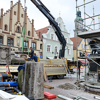 Mithilfe eines Hebekrans werden die schweren Granitblöcke abtransportiert. (Foto: Stadt Freising)