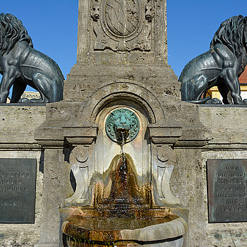 Zwei Bronzelöwen flankieren den Obelisk. Tafel-Inschriften: "Weil die Toten schweigen, beginnt immer wieder alles von vorn" (rechts); "Unser Opfer ist eure Verpflichtung. Frieden" (links). Foto: Stadt Freising