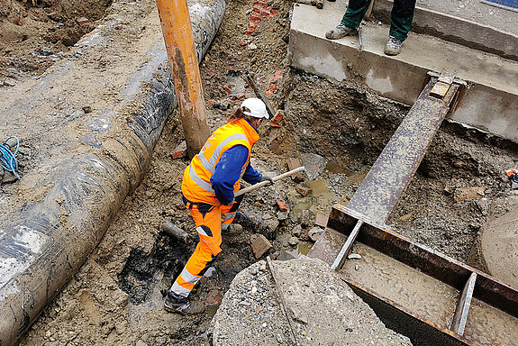 Per Hand müssen unterstützend Holz- und Zementbrocken gelöst werden, damit das Saugrohr seinen Dienst verrichten kann. (Foto: Stadt Freising)