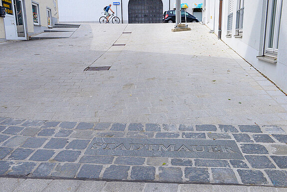 Wo sich einst die Stadtmauer befand, wurde diese mit einem abgesetzten Pflasterbelag nachempfunden.(Foto: Stadt Freising)
