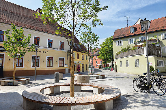 Der neu gestaltete Platz vor dem Landshuter Hof - um die Bäume bieten Rundbänke Platz zum Verweilen. (Foto: Stadt Freising)