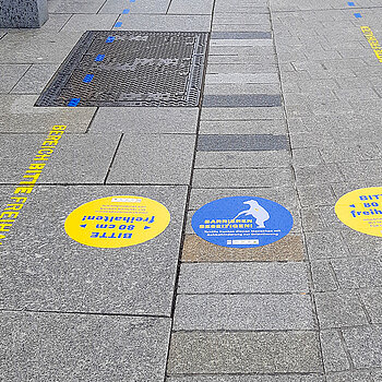 Gelbe und blaue Aufkleber machen zusätzlich deutlich, dass der barrierefreie Streifen für Menschen mit Sehbehinderung zur Orientierung dient. (Foto: Stadt Freising)