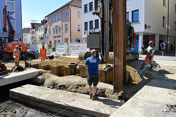 Millimeterarbeit: Bevor die Spundbohle eingerüttelt wird, wird sie exakt in Position gebracht. (Foto: Stadt Freising)