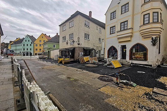 Links im Bild der fertige Pflasterstreifen entlang der Südfassaden - jetzt werden auch auf der Nordseite große Platten verlegt. (Foto: Stadt Freising)