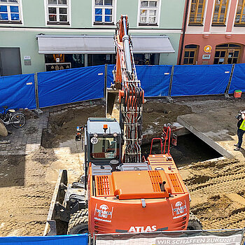 Blick von oben auf die Arbeiten für Moosach-Öffnung in der Oberen Hauptstraße - hier der erste Bauabschnitt, bei dem das Uferbett saniert, der Bachlauf etwas verschoben und dann wieder geschlossen wird. (Foto: Stadt Freising)